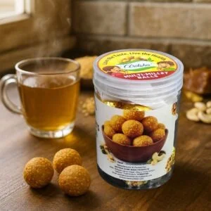 Aritsha Multimillet Urundai jar with millet laddu balls served beside herbal tea on wooden table